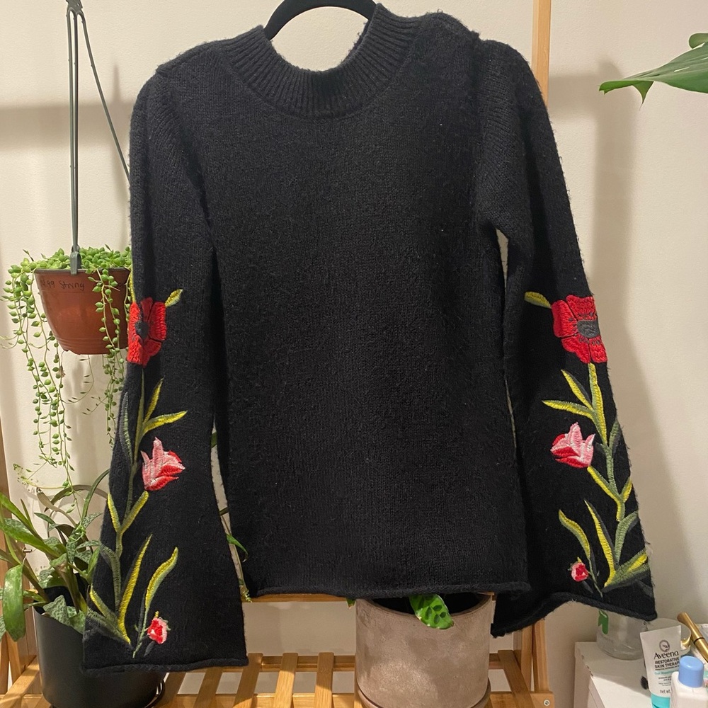 Black sweater with flare arms and floral pattern